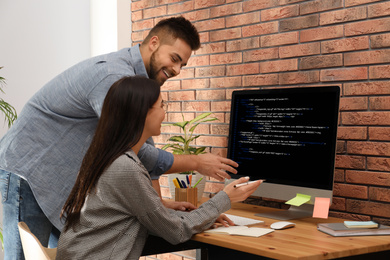 Professional programmers working with computer in office