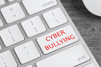 Image of Modern laptop keyboard with phrase CYBER BULLYING on white button, closeup 