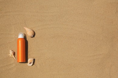 Photo of Sunscreen and seashells on sand, flat lay with space for text. Sun protection care