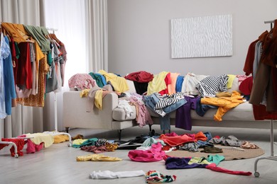 Photo of Mess of clothes all over room. Fast fashion