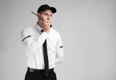 Photo of Male security guard using portable radio transmitter on color background