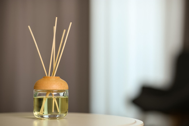 Aromatic reed air freshener on table indoors. Space for text