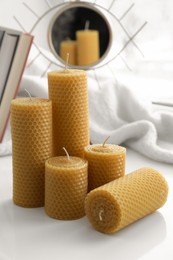 Beautiful yellow beeswax candles on white table
