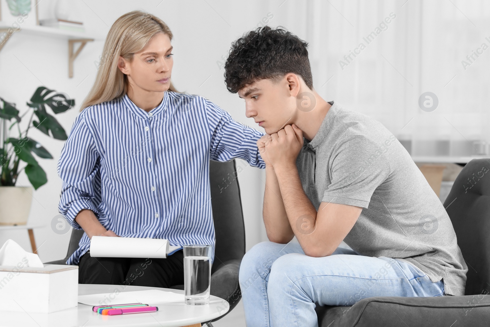 Photo of Psychologist working with teenage boy in office. Teenager problems