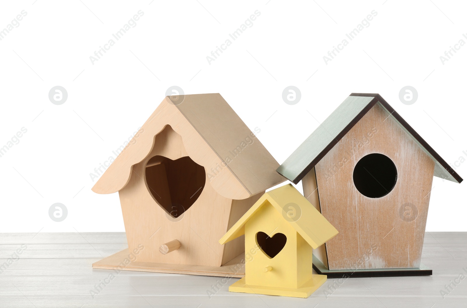 Photo of Three different bird houses on white background