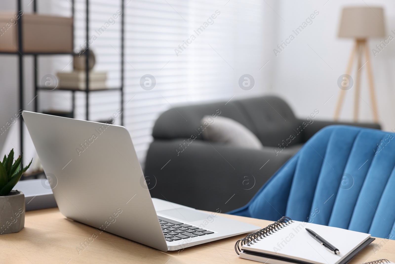 Photo of Home workspace. Laptop and stationery on wooden desk indoors