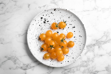 Photo of Ripe yellow tomatoes on white marble table, top view