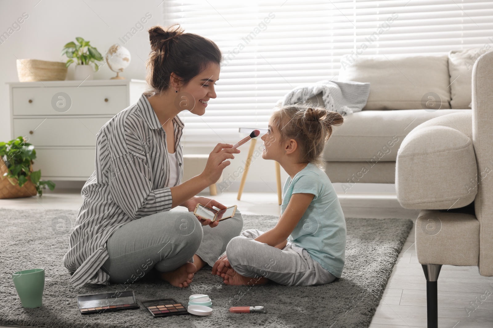 Photo of Young mother and her daughter spending time together at home