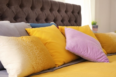 Photo of Different pillows on bed in room. Idea for interior decor