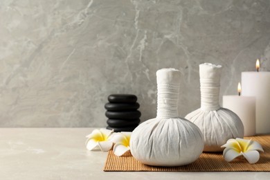 Spa bags, stones and scented candles on light gray table