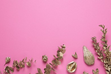 Flat lay composition with golden dried flowers and eucalyptus branches on pink background. Space for text