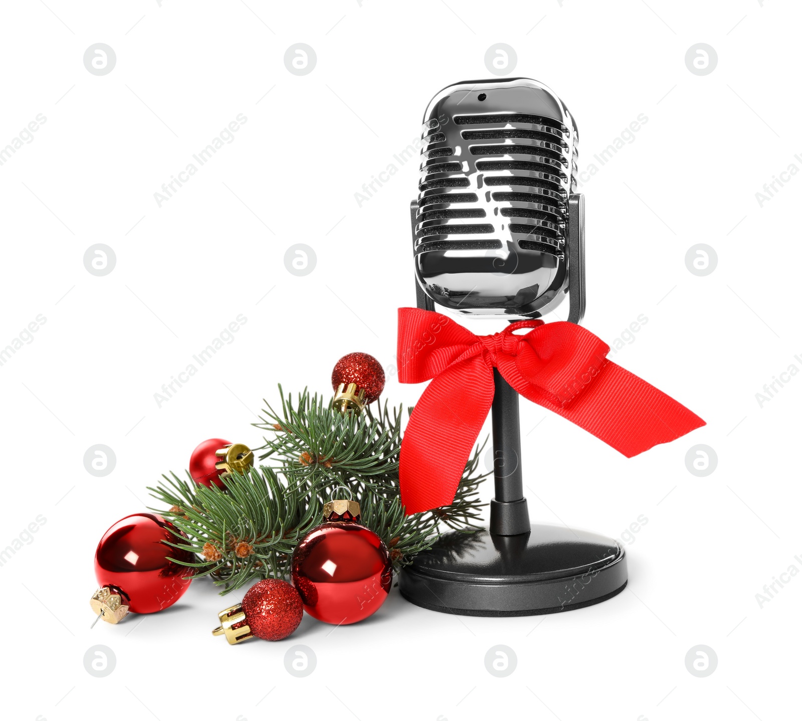 Photo of Retro microphone with red bow and festive decor on white background. Christmas music