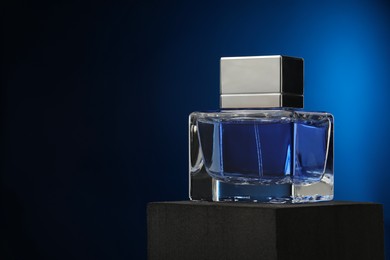 Photo of Luxury men`s perfume in bottle against dark background, space for text