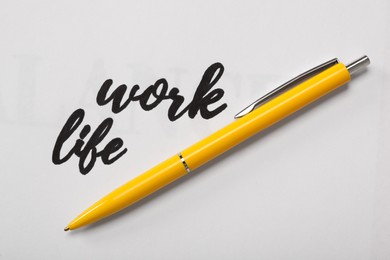 Photo of Text Work, Life and pen on white background, top view. Balance concept