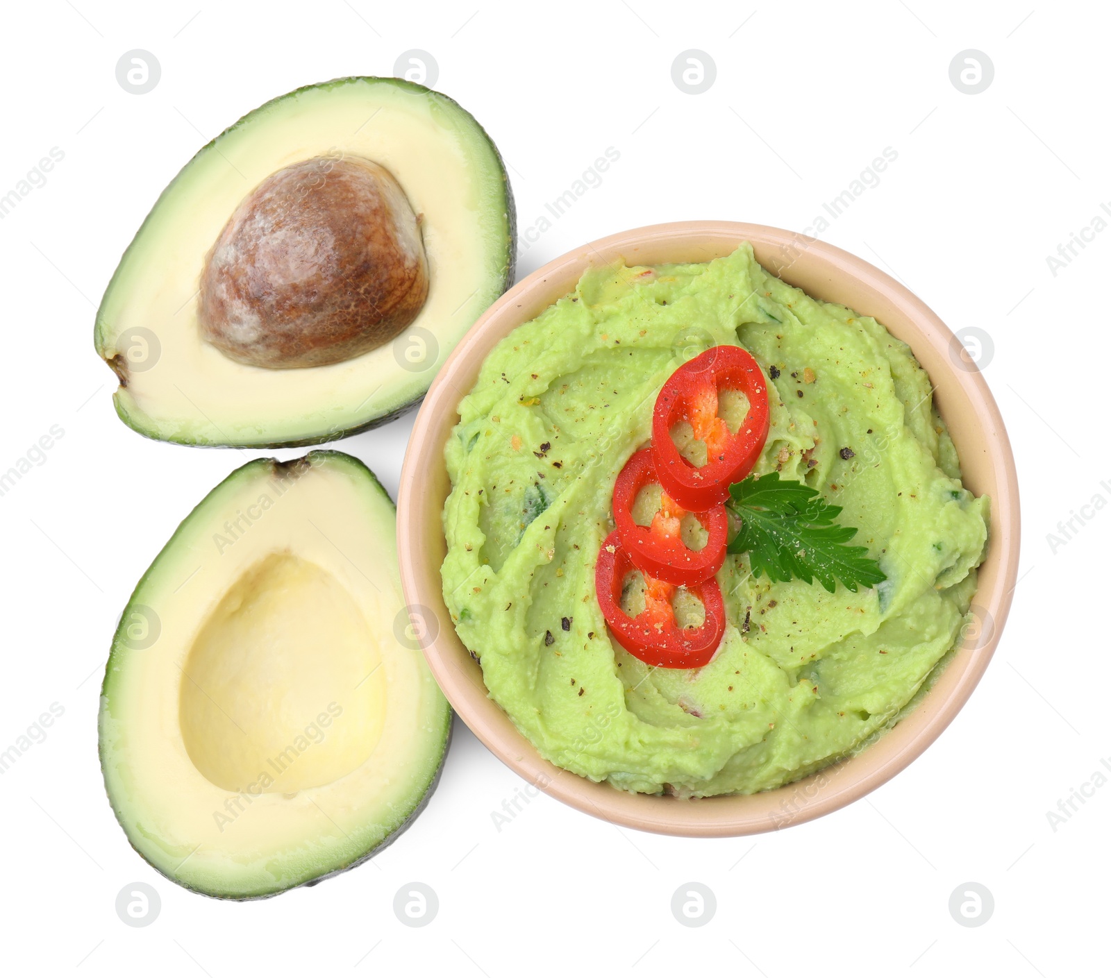Photo of Bowl of delicious guacamole with chili pepper and fresh avocado isolated on white, top view