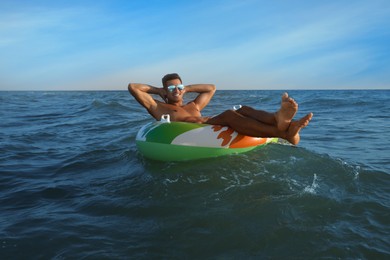 Photo of Man with inflatable ring resting in sea