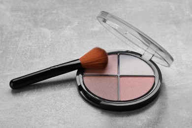 Photo of Contouring palette and brush on light gray background. Professional cosmetic product