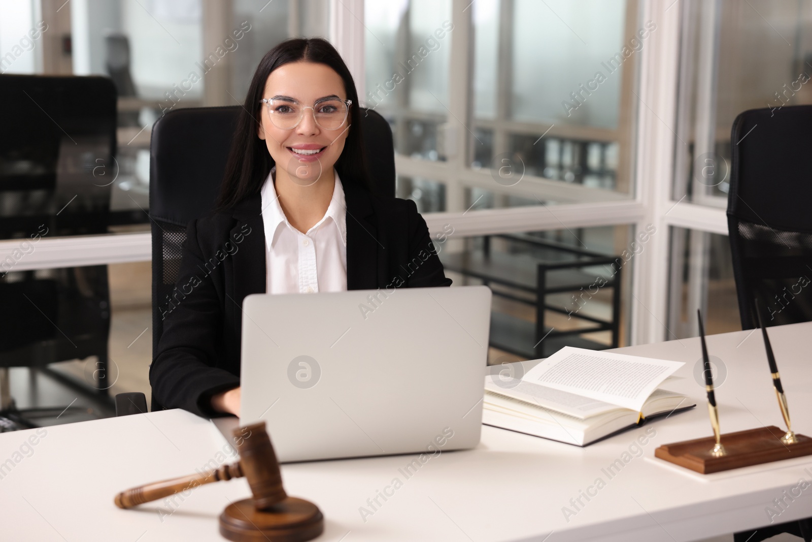 Photo of Smiling lawyer working on laptop in office