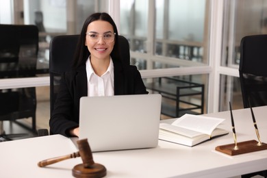 Smiling lawyer working on laptop in office