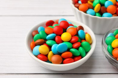 Photo of Tasty colorful candies on white wooden table, closeup