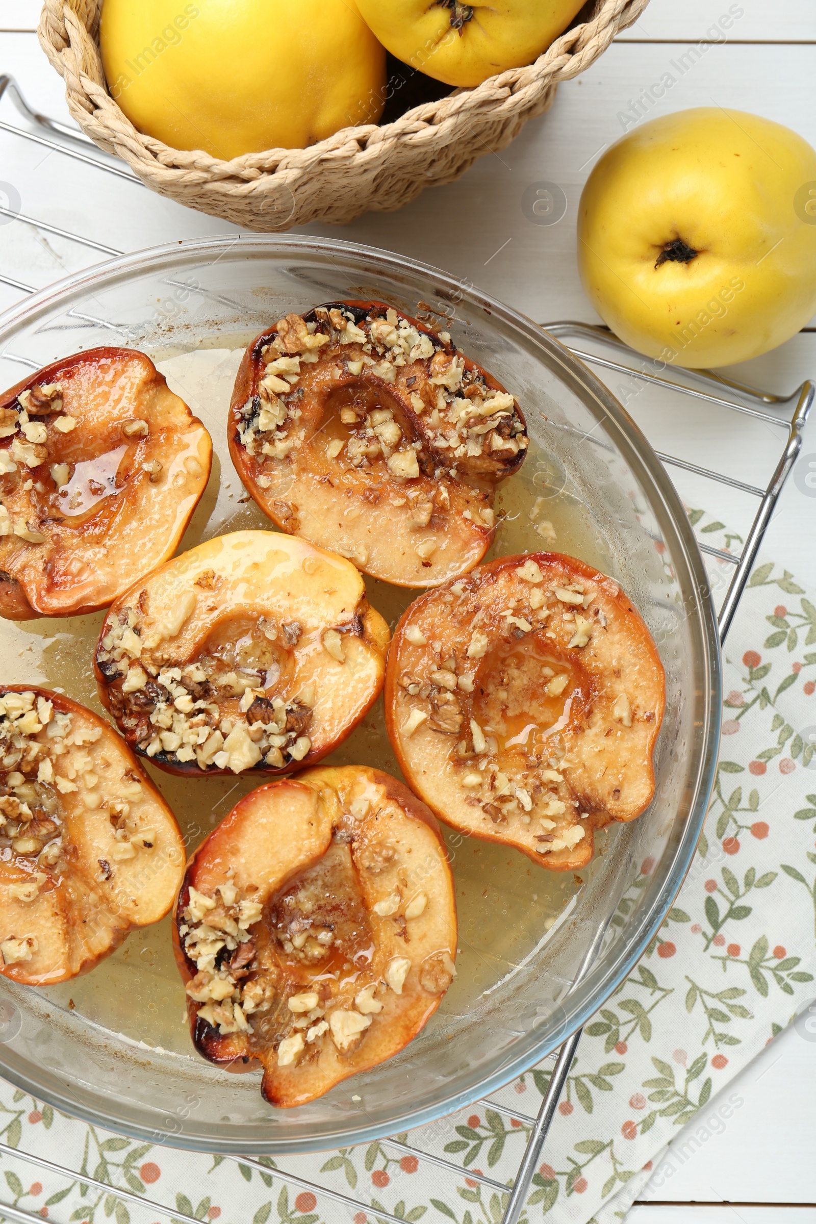 Photo of Delicious baked quinces with nuts in bowl and fresh fruits on table, flat lay