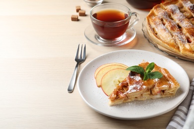 Photo of Slice of traditional apple pie served on wooden table. Space for text
