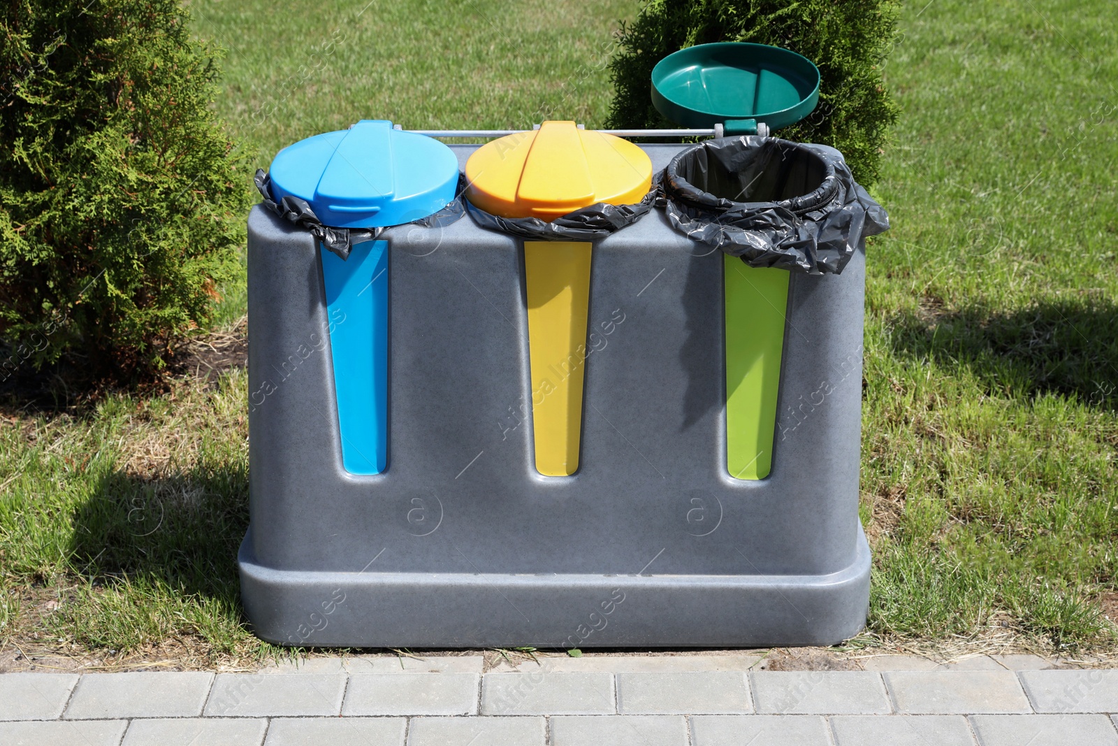 Photo of Recycling bins for different garbage outdoors. Waste sorting