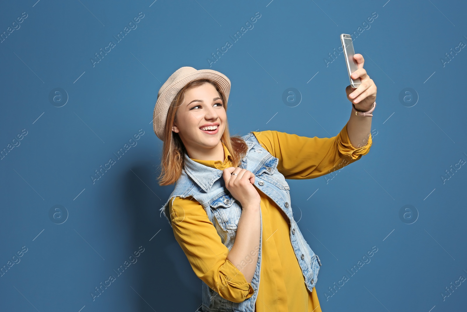 Photo of Attractive young woman taking selfie on color background