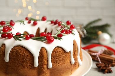 Traditional Christmas cake with cranberries, pomegranate seeds and rosemary on table, closeup