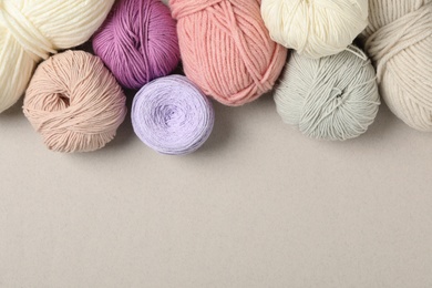 Soft woolen yarns on light background, flat lay. Space for text