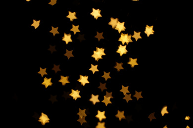 Photo of Blurred view of star shaped lights on black background. Bokeh effect