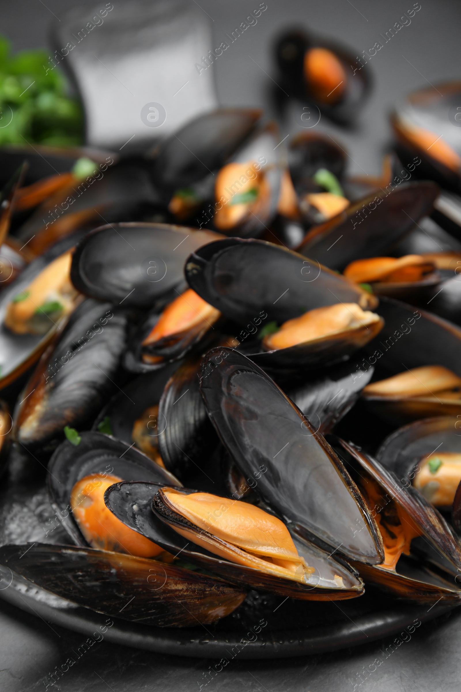 Photo of Serving slate board with cooked mussels on table, closeup