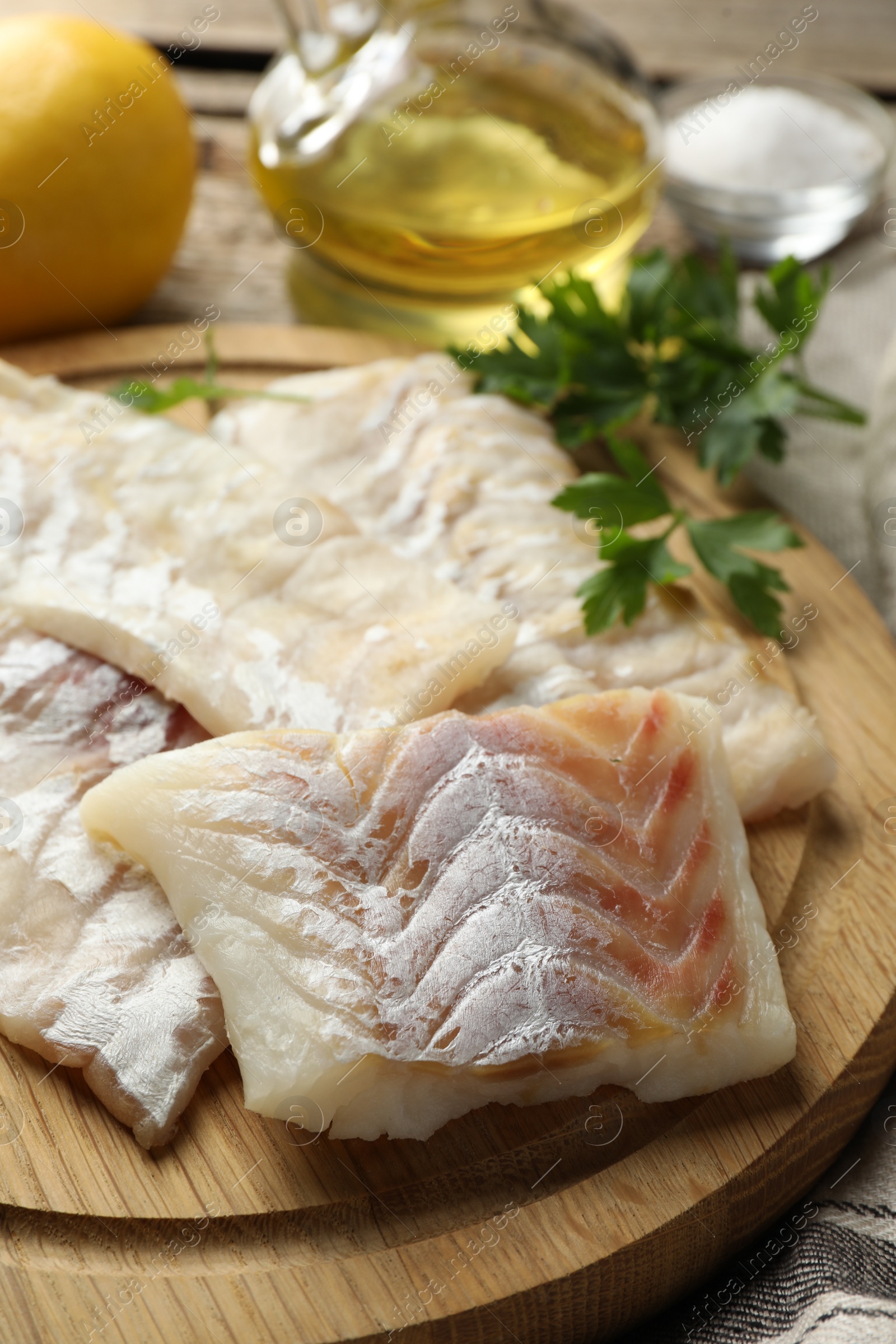 Photo of Fresh raw cod fillets on wooden table, closeup