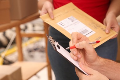 Photo of Post office workers checking parcel barcode indoors, closeup