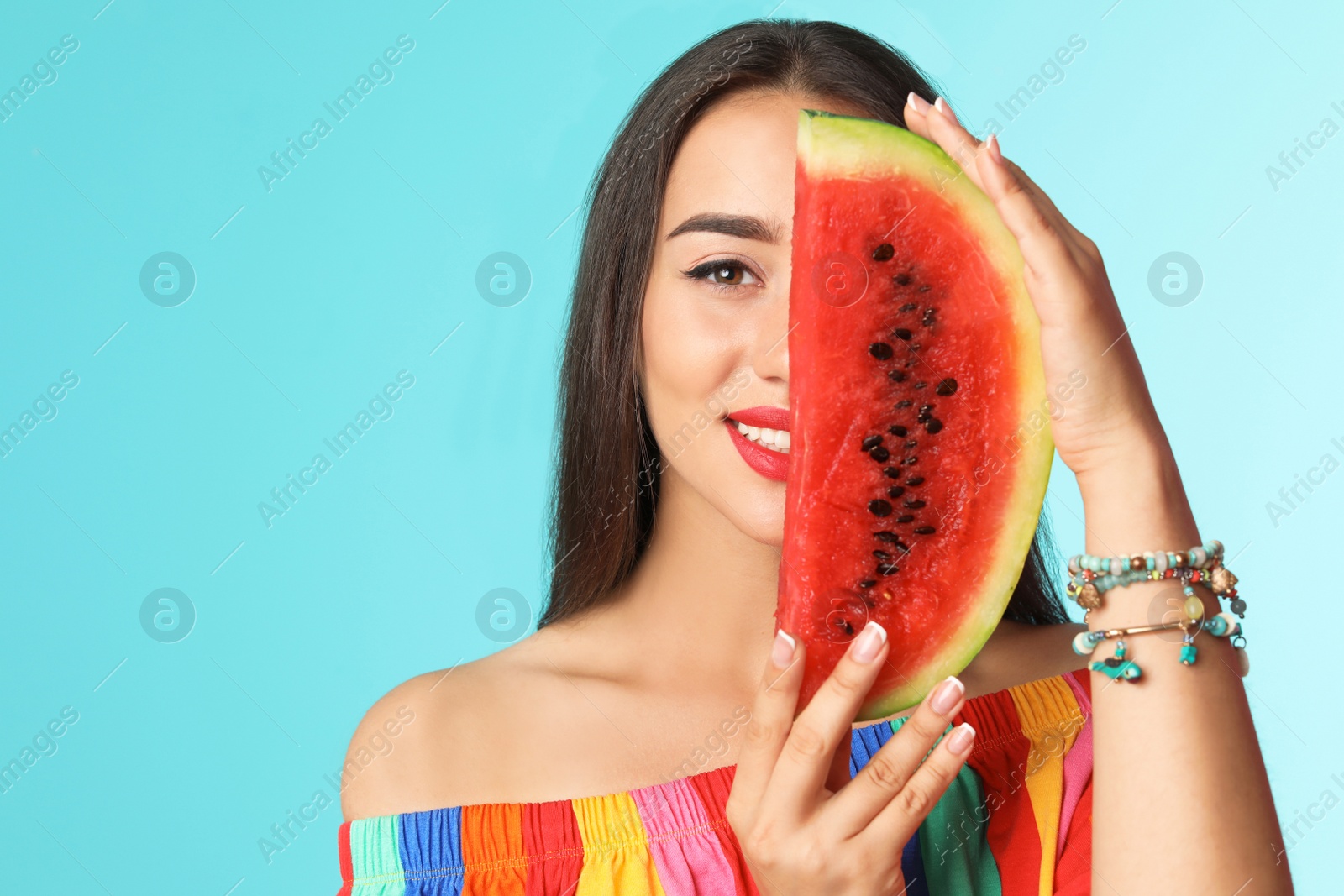 Photo of Beautiful young woman posing with watermelon on color background