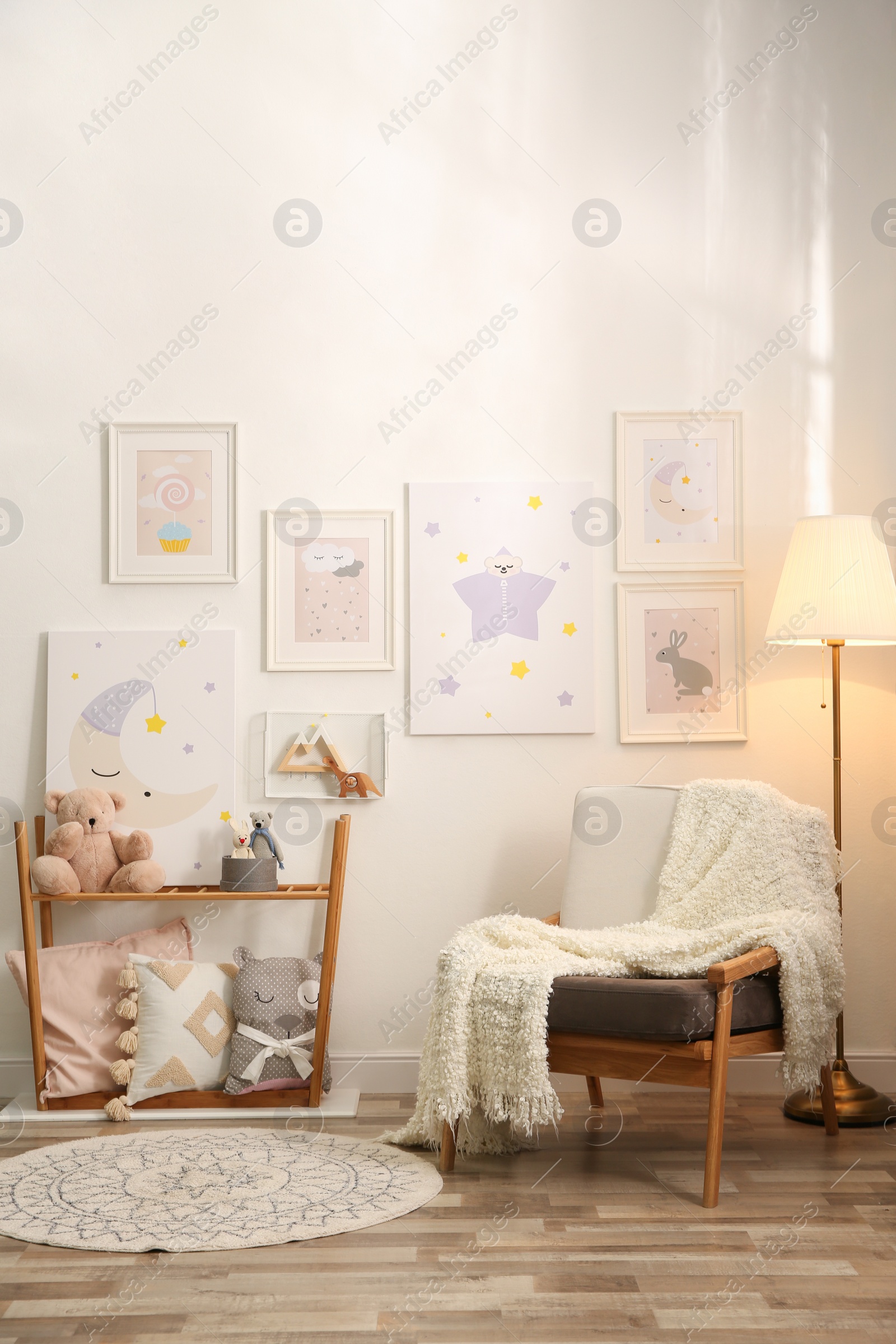 Photo of Stylish child's room interior with comfortable armchair and beautiful pictures