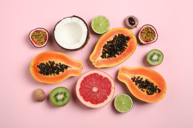 Photo of Fresh ripe papaya and other fruits on pink background, flat lay
