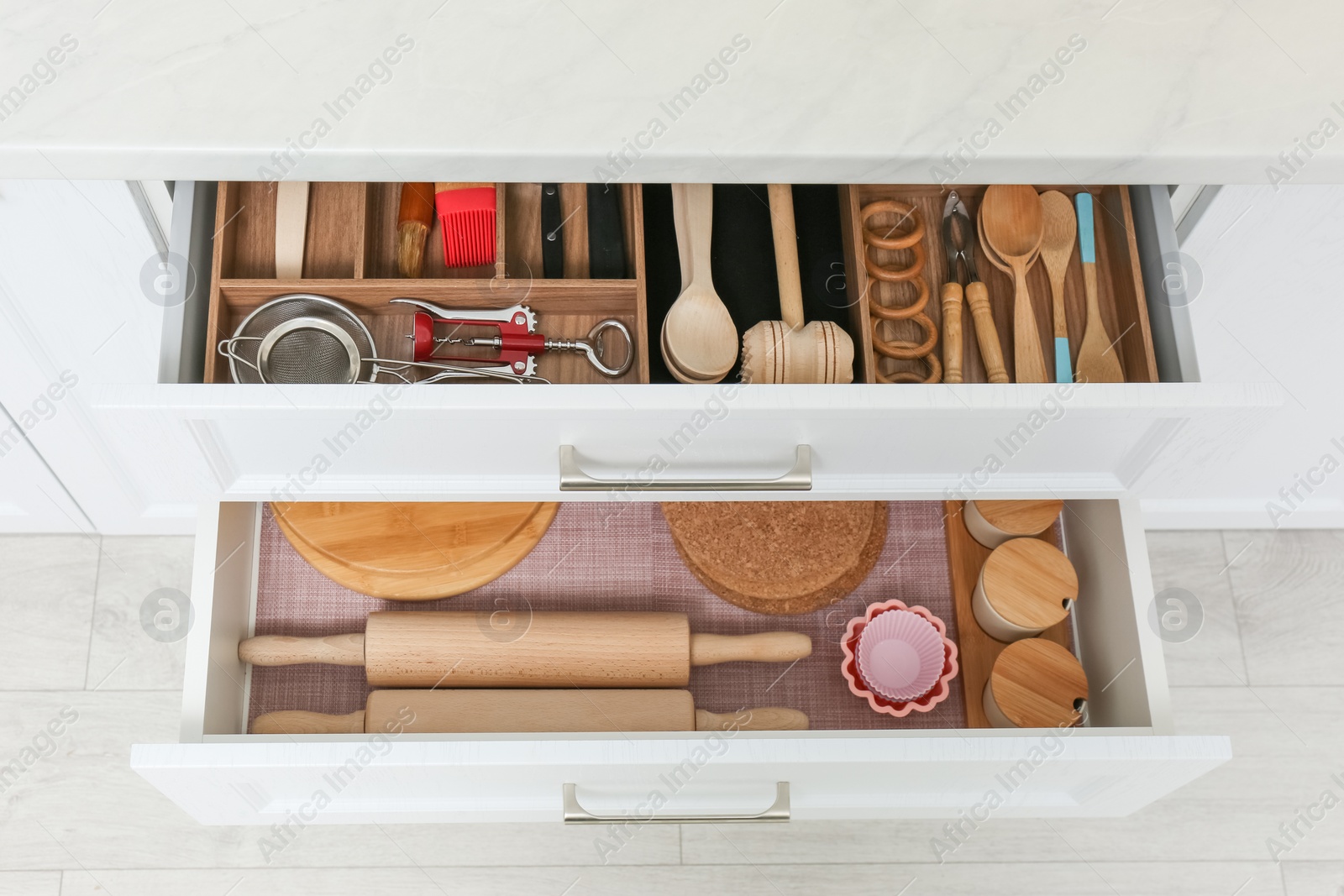 Photo of Open drawers with cutlery and utensils indoors. Order in kitchen