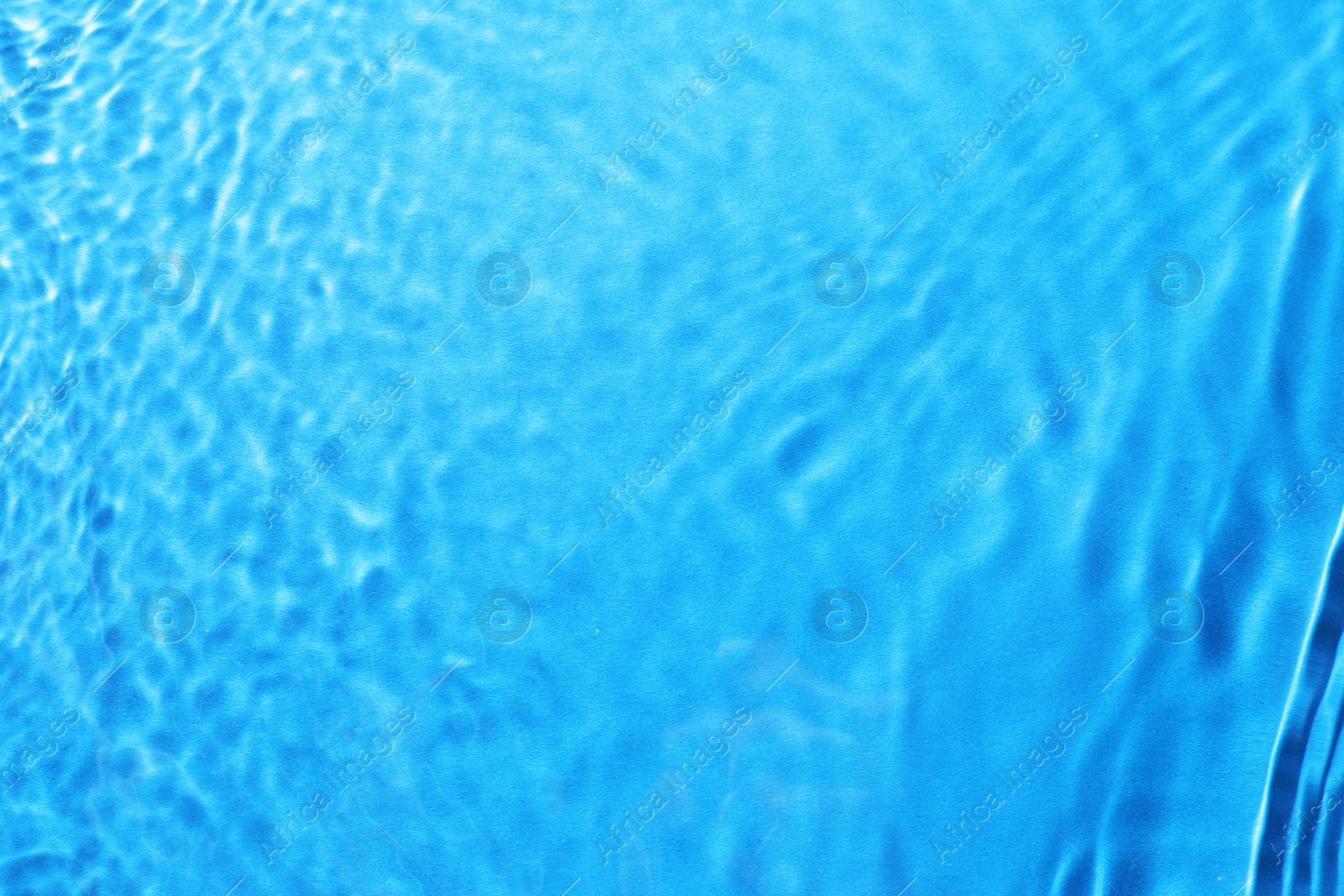 Image of Rippled surface of clear water on light blue background, top view