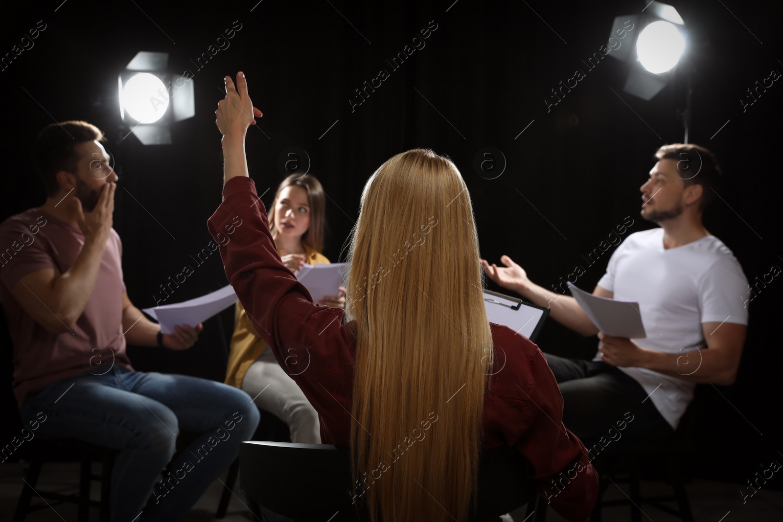 Photo of Professional actors reading their scripts during rehearsal in theatre