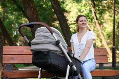 Photo of Happy nanny with baby in stroller in park