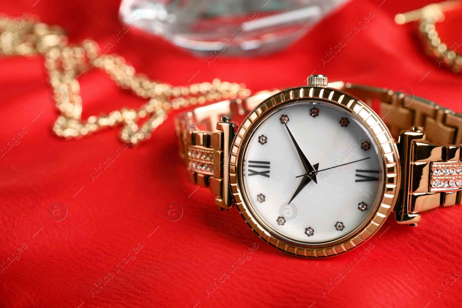 Photo of Luxury wrist watch on red background, closeup