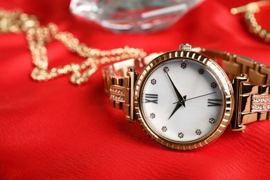 Photo of Luxury wrist watch on red background, closeup