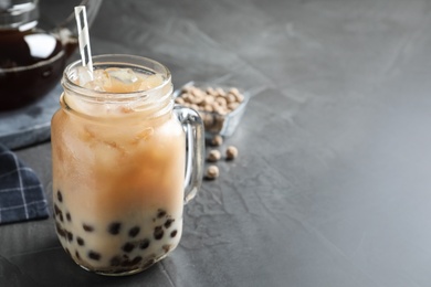 Tasty brown milk bubble tea on grey table, closeup. Space for text