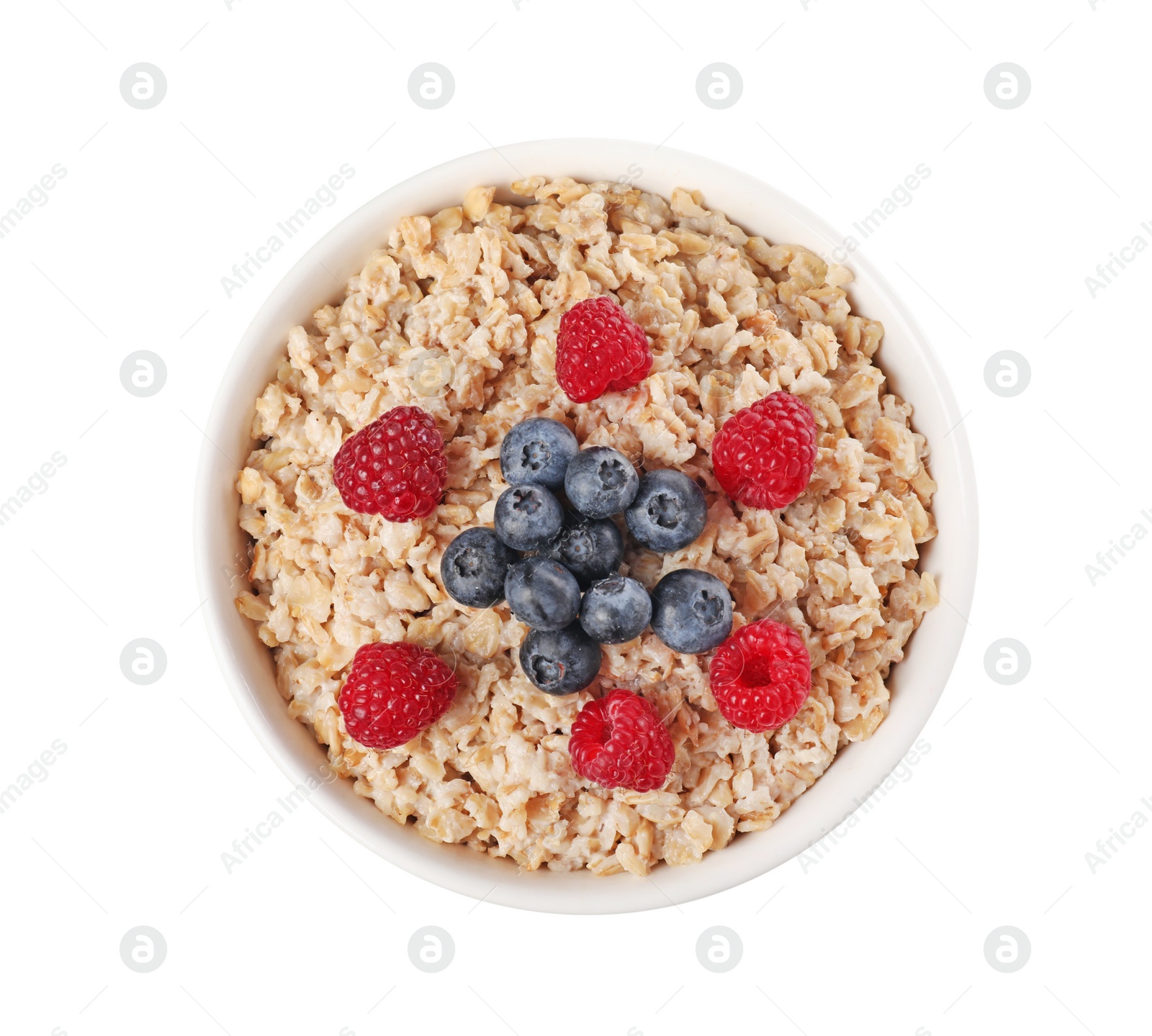 Photo of Tasty boiled oatmeal with berries in bowl isolated on white, top view