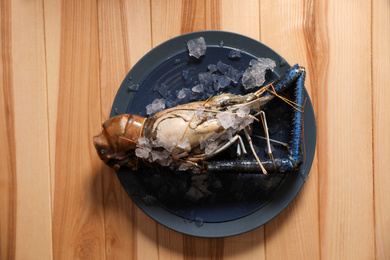 Fresh malaysian freshwater prawn with ice on wooden table, top view