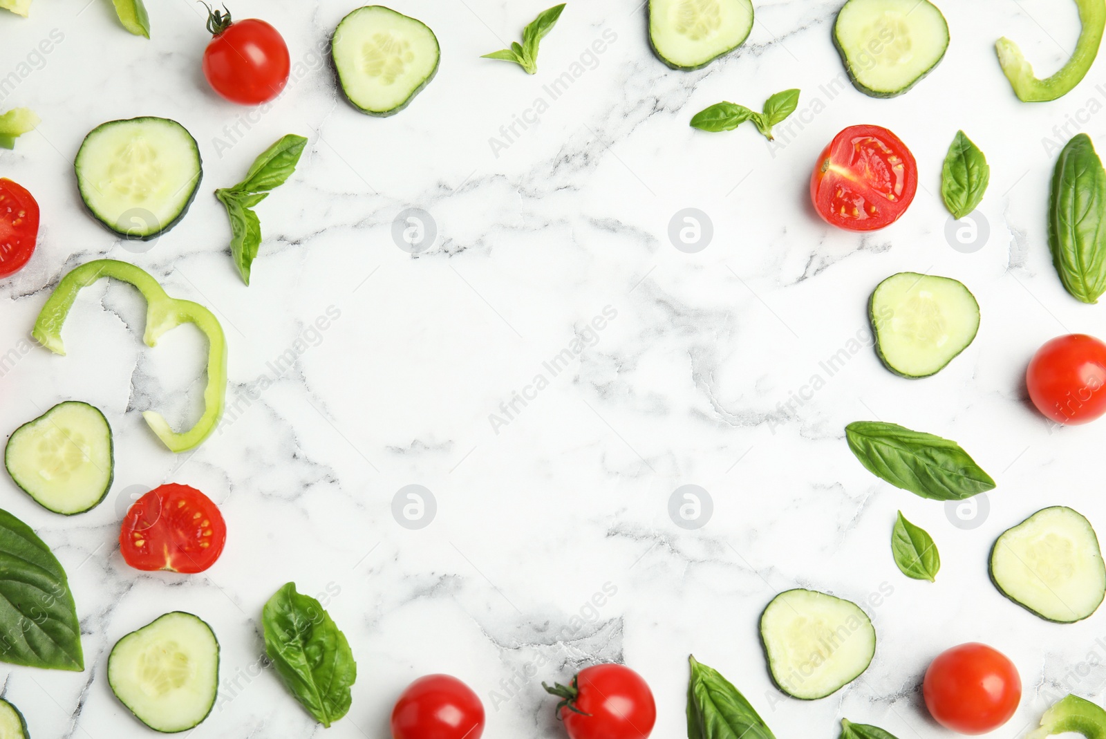 Photo of Frame made with fresh salad ingredients on white marble table, flat lay. Space for text