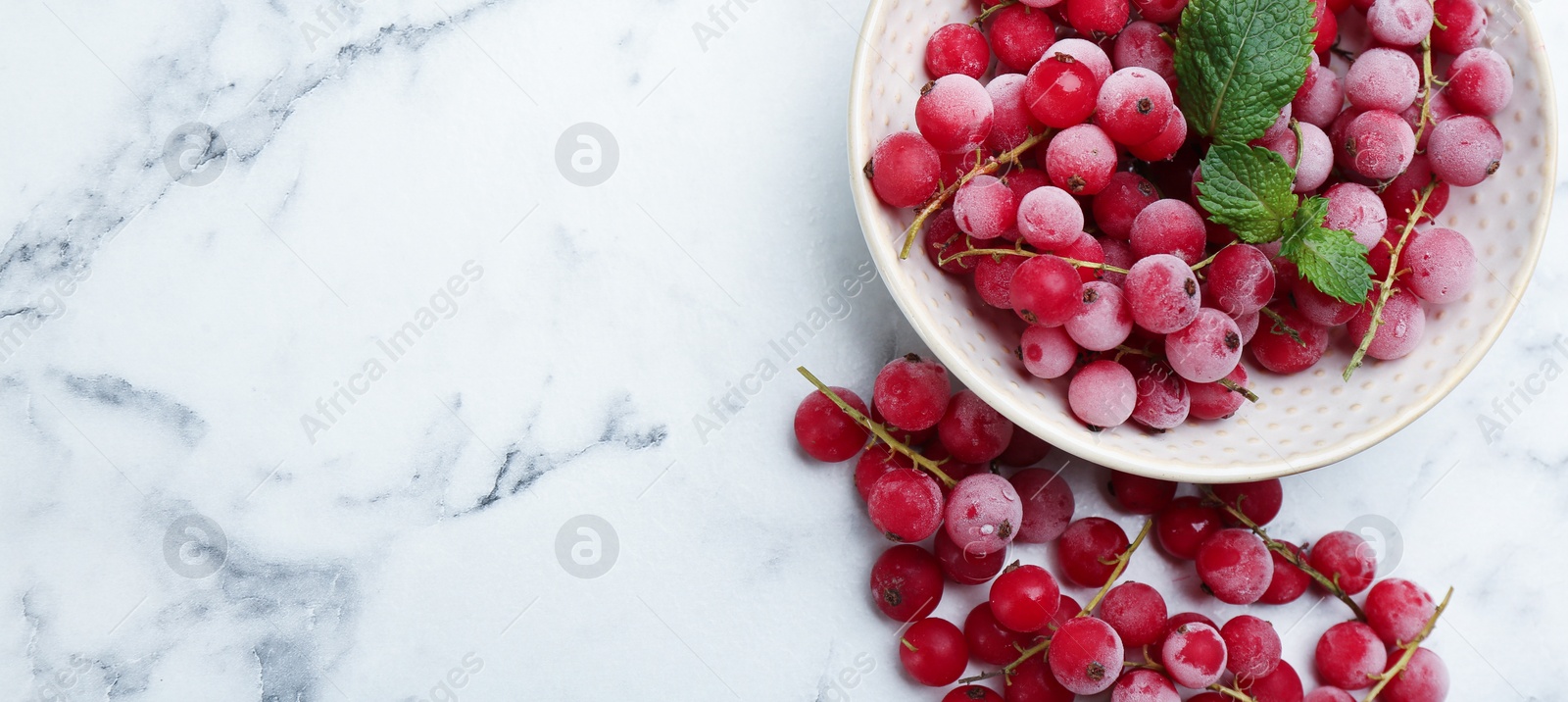 Photo of Tasty frozen red currants on white marble table, flat lay. Space for text