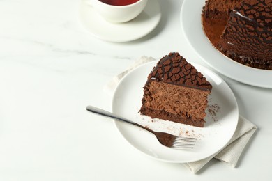 Piece of delicious chocolate truffle cake on white marble table, space for text