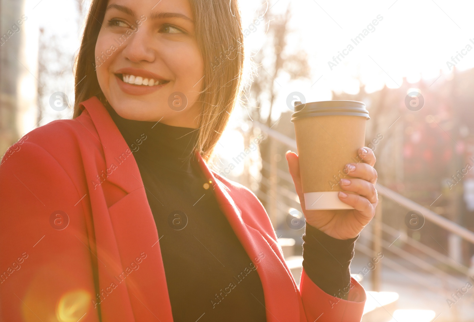 Photo of Businesswoman with cup of coffee on city street in morning